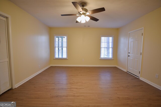 interior space featuring visible vents, a ceiling fan, wood finished floors, and a healthy amount of sunlight