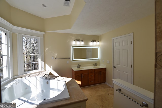 bathroom featuring vanity, a bath, tile patterned flooring, and a textured ceiling