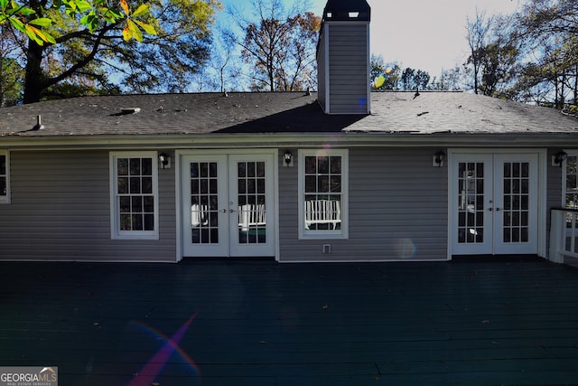 back of house with a chimney, a shingled roof, french doors, and a deck