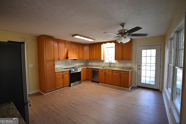 unfurnished living room with crown molding, ceiling fan, dark wood-type flooring, and a textured ceiling