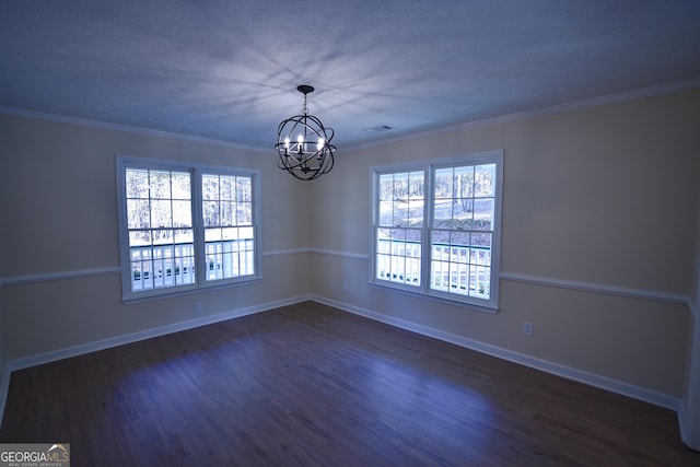 spare room featuring dark wood finished floors, baseboards, visible vents, ornamental molding, and an inviting chandelier