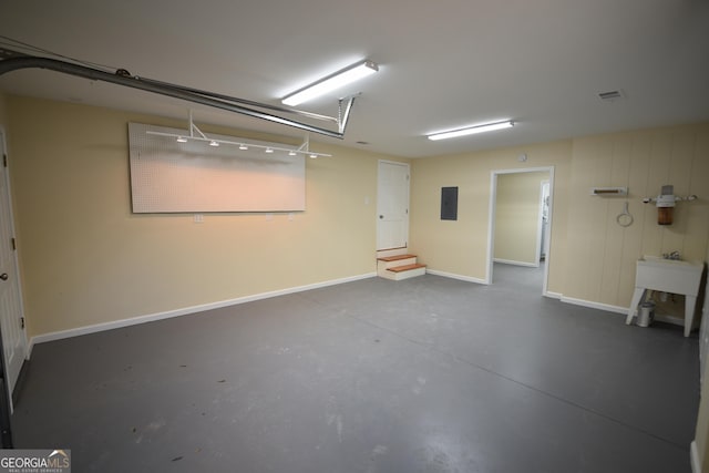 garage featuring electric panel, baseboards, and visible vents
