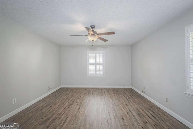 spare room featuring ceiling fan, dark hardwood / wood-style flooring, and a textured ceiling