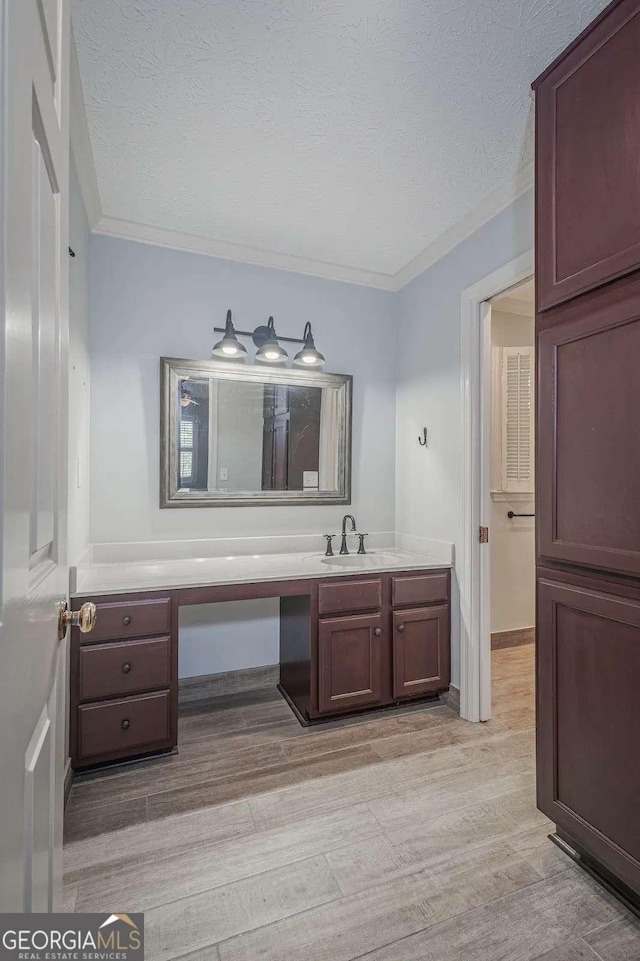 bathroom featuring vanity, wood-type flooring, and a textured ceiling