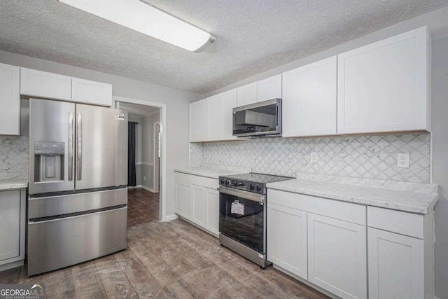 kitchen featuring white cabinetry, light wood-type flooring, and appliances with stainless steel finishes