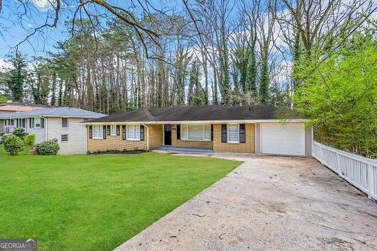 ranch-style house featuring a front yard and a garage