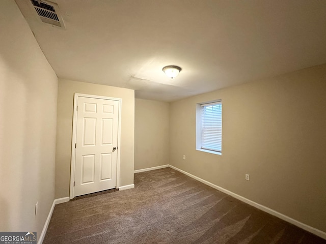 unfurnished bedroom featuring dark colored carpet and a closet