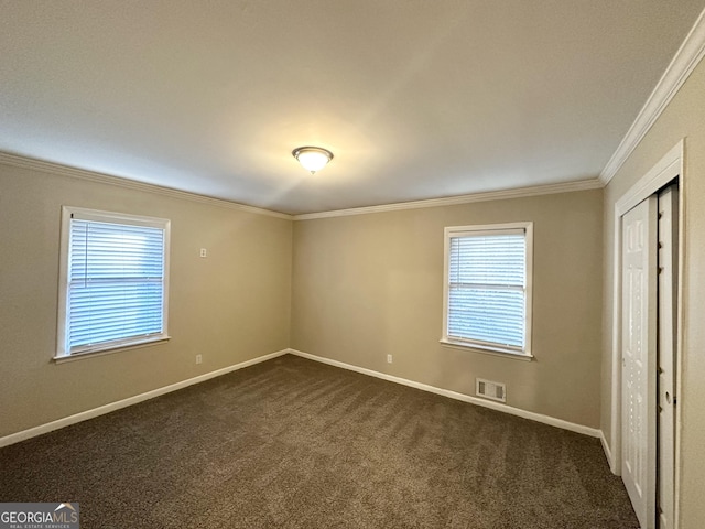 carpeted spare room featuring crown molding