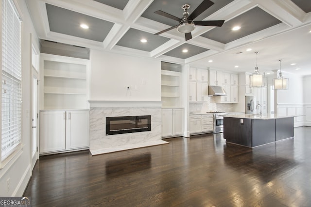 living room with dark hardwood / wood-style flooring, coffered ceiling, ceiling fan, beam ceiling, and a premium fireplace