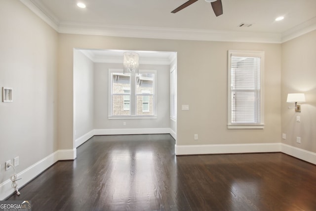 spare room with dark hardwood / wood-style floors, ornamental molding, and ceiling fan with notable chandelier