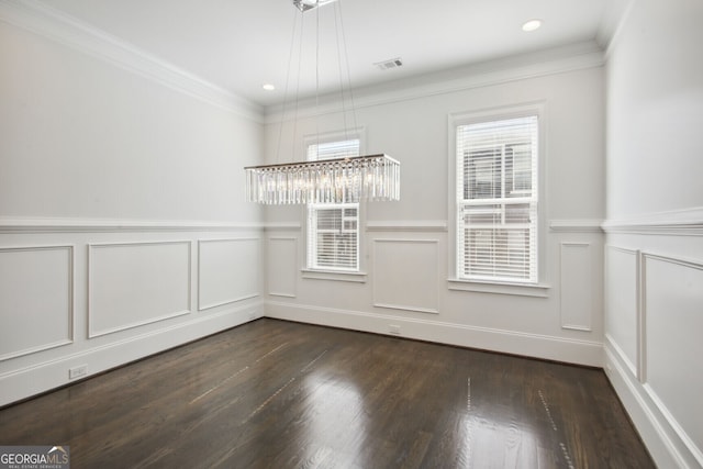 empty room with ornamental molding, a wealth of natural light, and dark wood-type flooring