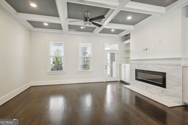 unfurnished living room with coffered ceiling, ceiling fan, beamed ceiling, a fireplace, and dark hardwood / wood-style floors