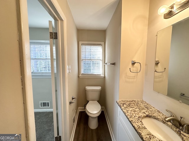 bathroom with hardwood / wood-style flooring, vanity, and toilet