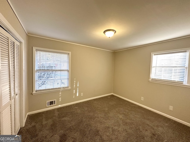 carpeted spare room with a wealth of natural light and crown molding