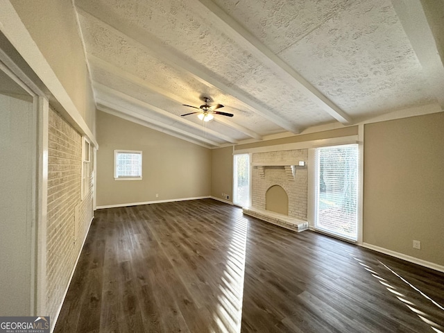 unfurnished living room featuring lofted ceiling with beams, dark wood-type flooring, and a healthy amount of sunlight