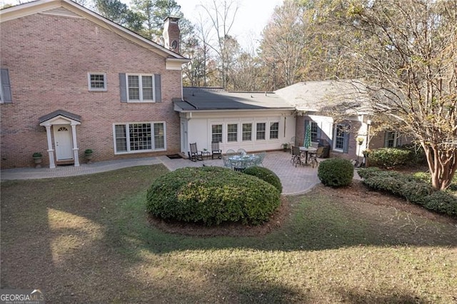 back of property with a patio and a lawn