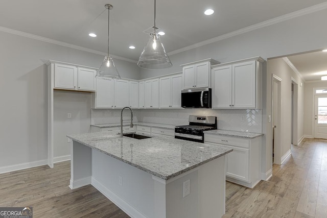 kitchen featuring white cabinetry, sink, stainless steel appliances, and a center island with sink