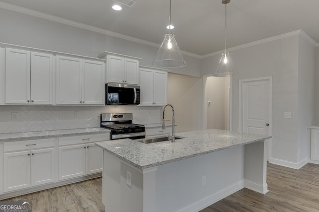 kitchen featuring an island with sink, sink, white cabinets, stainless steel appliances, and light stone countertops