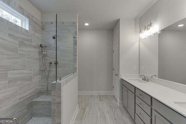 bathroom with vanity and a tile shower