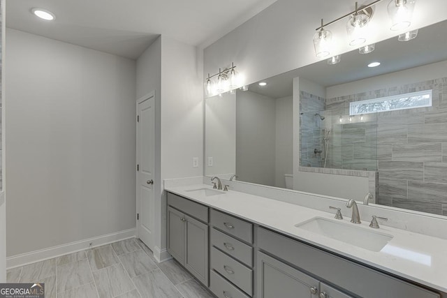 bathroom with tiled shower and vanity