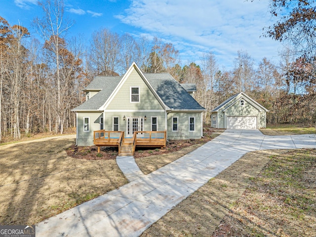 view of front facade featuring a front yard, an outbuilding, a wooden deck, and a garage