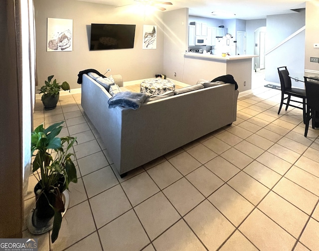 tiled living room featuring ceiling fan