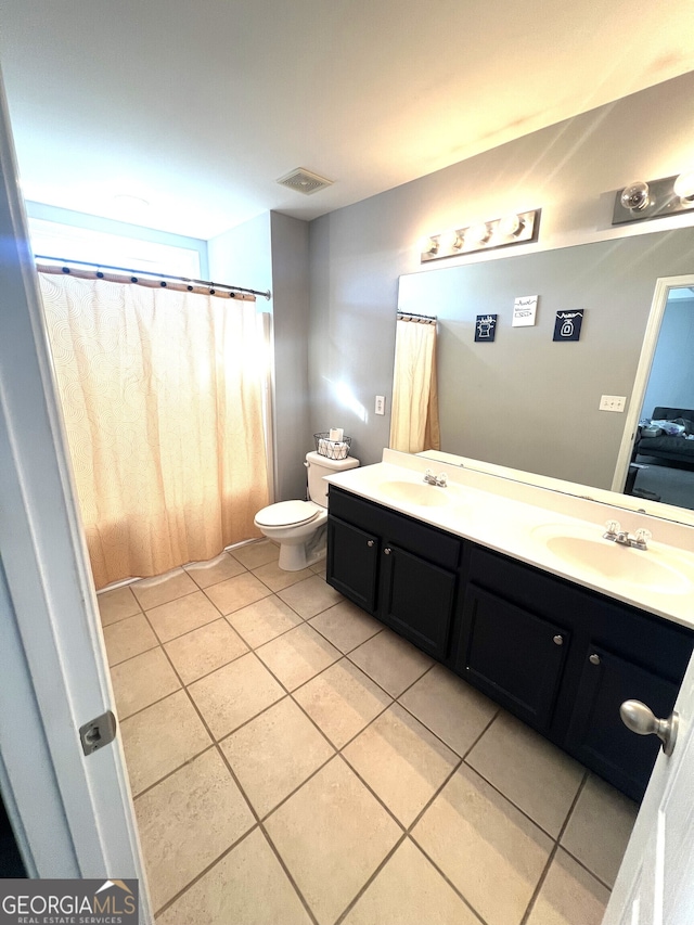 bathroom featuring toilet, vanity, and tile patterned floors