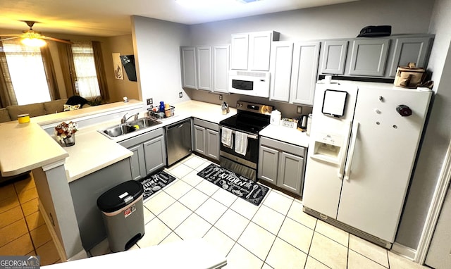 kitchen with sink, gray cabinets, light tile patterned flooring, kitchen peninsula, and stainless steel appliances