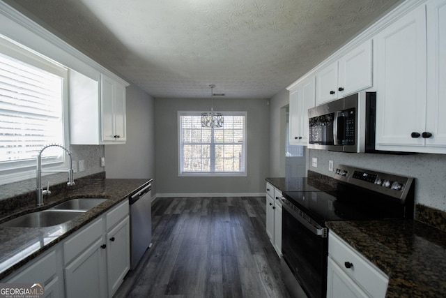 kitchen with sink, hanging light fixtures, dark hardwood / wood-style floors, white cabinets, and appliances with stainless steel finishes