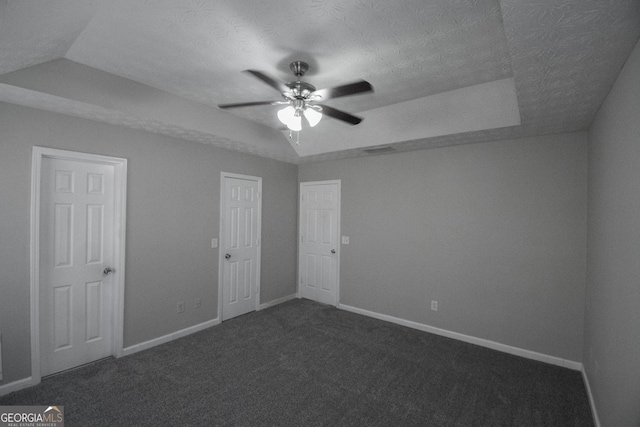 carpeted spare room with vaulted ceiling, ceiling fan, and a textured ceiling