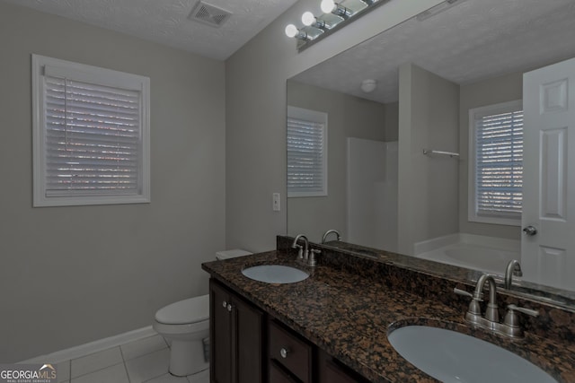 bathroom with vanity, tile patterned floors, a washtub, toilet, and a textured ceiling