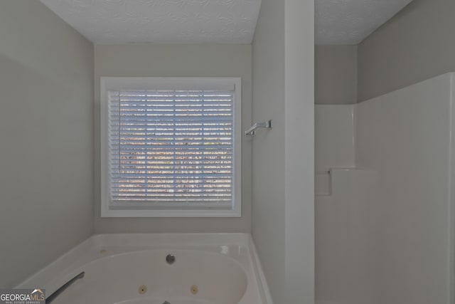 bathroom featuring a tub to relax in and a textured ceiling