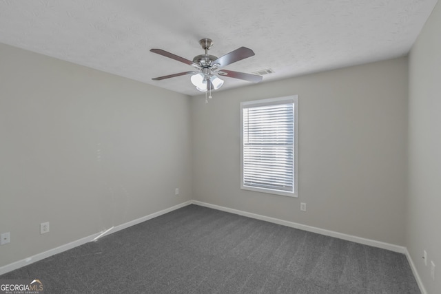 carpeted empty room featuring ceiling fan and a textured ceiling