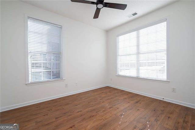 spare room with dark hardwood / wood-style flooring and ceiling fan