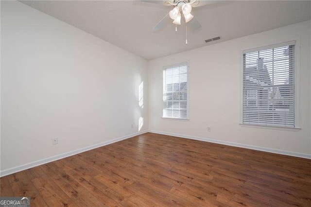 unfurnished room with dark hardwood / wood-style flooring, a wealth of natural light, and ceiling fan