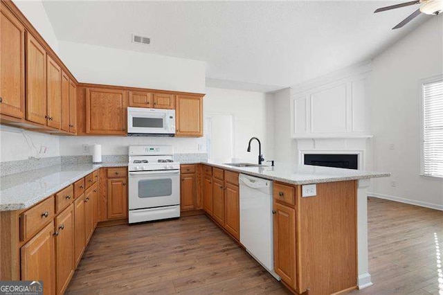 kitchen with sink, white appliances, dark hardwood / wood-style floors, and kitchen peninsula