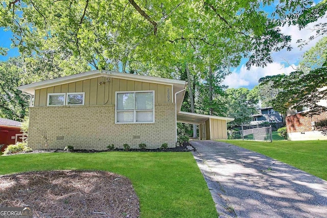 view of front of property with a front yard and a carport