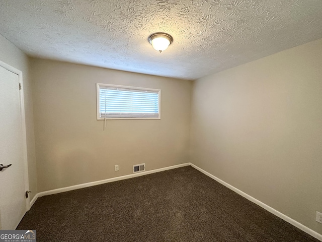 carpeted empty room with a textured ceiling