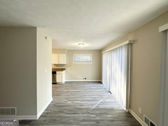 unfurnished living room with a textured ceiling and hardwood / wood-style flooring