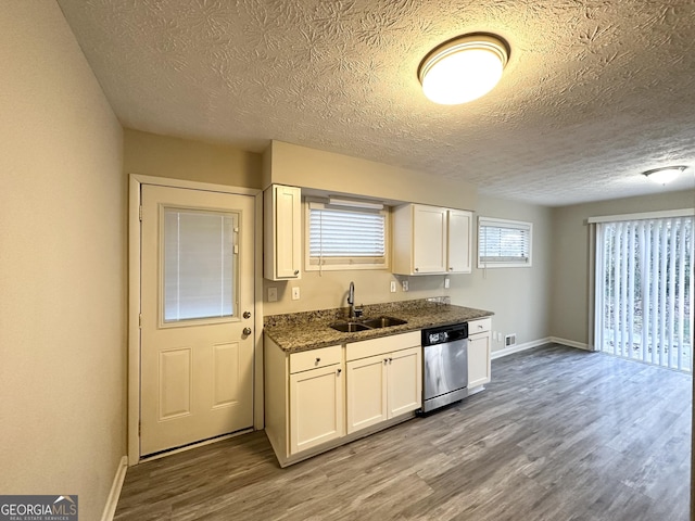 kitchen featuring dishwasher, light hardwood / wood-style floors, white cabinetry, and sink