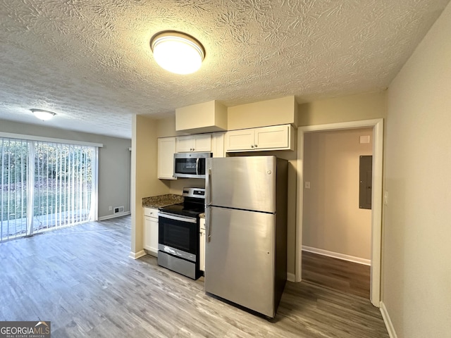 kitchen featuring white cabinets, appliances with stainless steel finishes, electric panel, and light hardwood / wood-style flooring