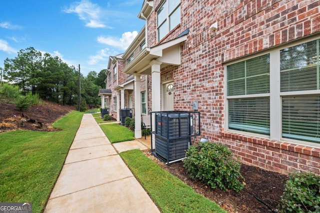 view of property exterior featuring a lawn and central air condition unit