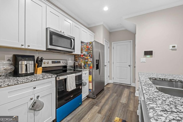 kitchen featuring dark hardwood / wood-style flooring, white cabinetry, stainless steel appliances, and ornamental molding