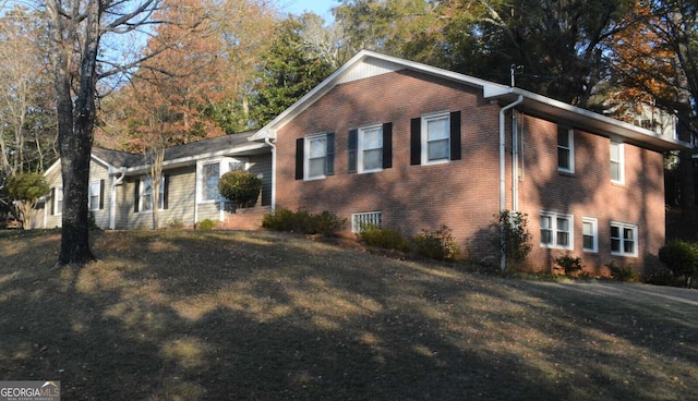 view of side of home with a lawn