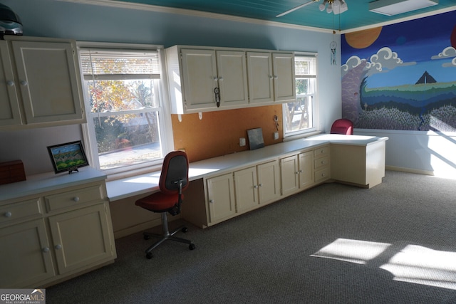 office featuring ornamental molding, light carpet, built in desk, and ceiling fan