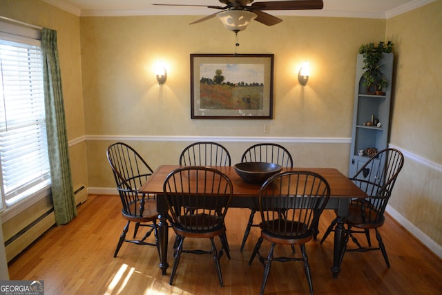 dining room featuring ornamental molding, ceiling fan, light wood-type flooring, and baseboard heating