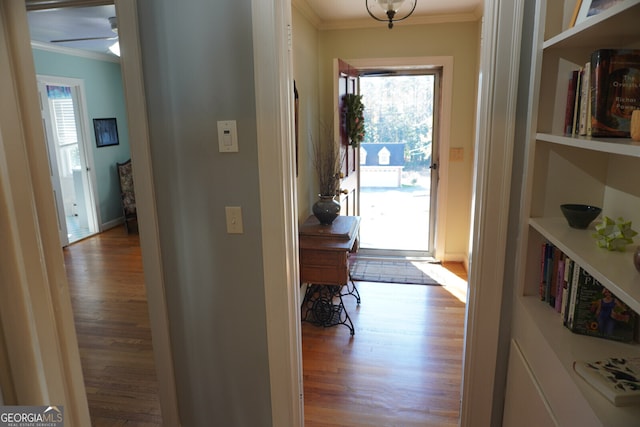 hall featuring plenty of natural light, ornamental molding, and light hardwood / wood-style floors