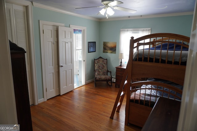 bedroom with wood-type flooring, ornamental molding, and ceiling fan