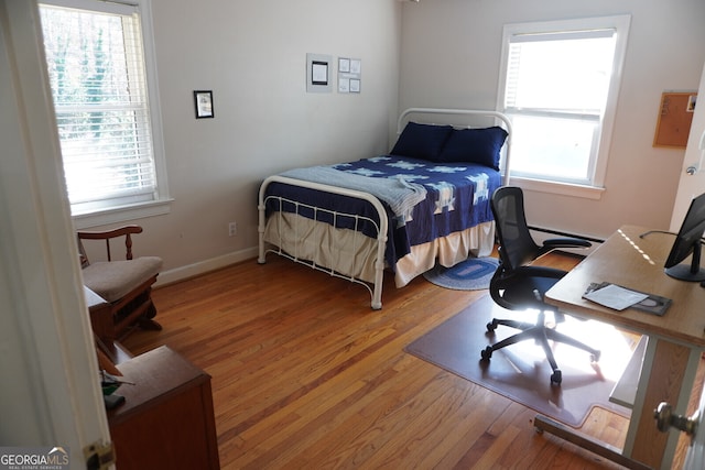 bedroom featuring wood-type flooring and multiple windows