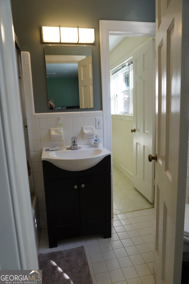 bathroom featuring vanity and tile walls